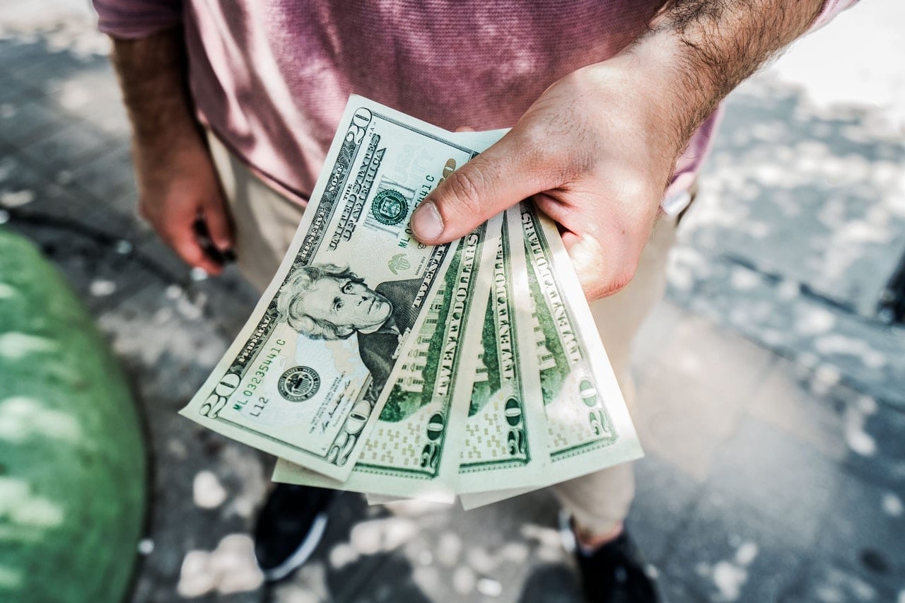 a man holding dollar bills